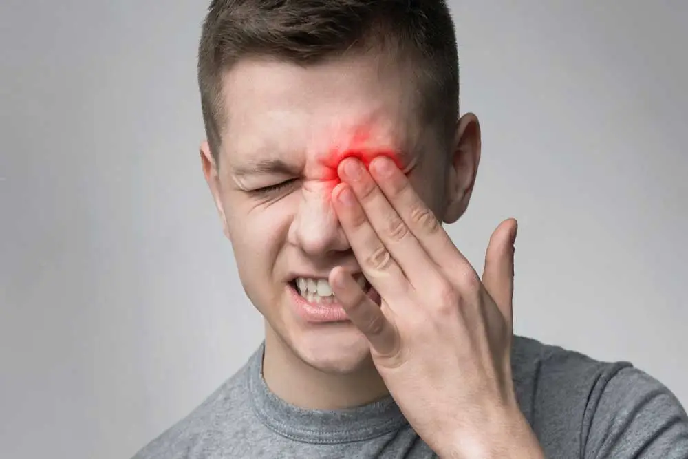 hommes se tient l'oeil douleur apres operation laser